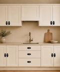 Four Pack Matte Black Cabinet Knobs With Sleek Backplates showcasing vintage floral petal details on beige kitchen cabinetry.