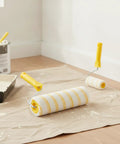 Premium Paint Roller Featuring Dual Yellow Strip Guide For Consistent Latex Flow Zero Streaks Killer Coverage on floor with tray.