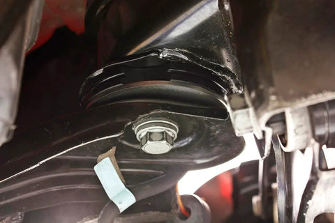 Close-up of Delrin Rear Cradle Bushing Kit Boasting Zinc Coated Sleeves installed on vehicle, showcasing heavy-duty performance.