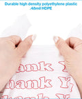 Hands holding White Thank You Bags Case Of 1000, 11.5 By 6 By 21 Inches, 0.48 Mil HDPE Plastic showcasing durability