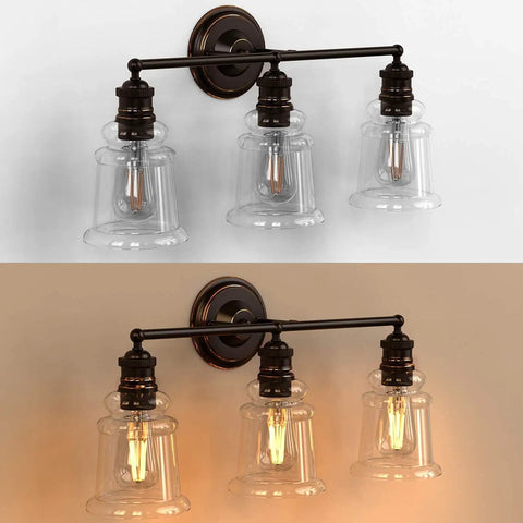 Three Light Vanity Light Dope Oil Rubbed Bronze With Clear Cylinder Glass, lighted and unlighted, over mirror bathroom fixture.