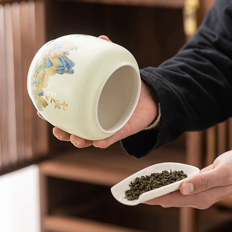 Top Shelf Ceramic Tea Tin With Woven Rattan Travel Case, Stunning Mountain Landscape Design, Go To Stash Jar For Loose Leaf Tea Or Specialty Coffee Beans In Slate Blue held while pouring loose leaf tea.