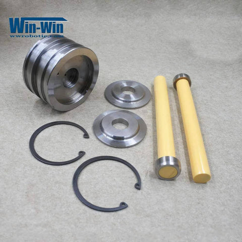Front view of Win-Win waterjet piston assembly spare parts laid out: two yellow rods, metal discs and rings (010561-1)