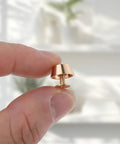 Top Tier Brass Purse Feet For Handbags And Totes - Screw Back Badass Bottom Guards with screw detail, held by a finger.