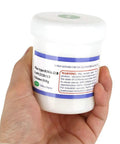 Hand holding Pro Grade Soldering Flux Paste 140g container with RMA-218 label for mobile phone PCBs, PGA and BGA repairs