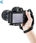 Hand holding camera with Pro Mirrorless Camera Hand Grip Strap With Arca Type Plate, Adjustable Length, Grippy No Slip Wrist Guard.