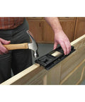 Man using Handy Door Hinge Template Kit With Lock-In Pins And Double Headed Nails, Fast Setup on a wooden door edge.