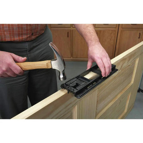 Man using Handy Door Hinge Template Kit With Lock-In Pins And Double Headed Nails, Fast Setup on a wooden door edge.