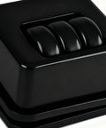 Close-up view of Furniture Casters Heavy-Duty Roller with three black wheels on an adhesive surface.