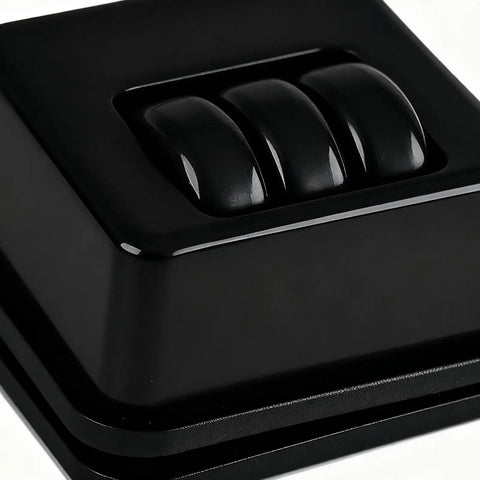 Close-up view of Furniture Casters Heavy-Duty Roller with three black wheels on an adhesive surface.