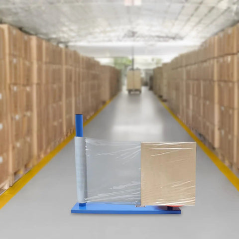 Badass Manual Stretch Film Dispenser For Pallet Wrap And Box Rolling No Sweat Design with a cardboard box in a warehouse.