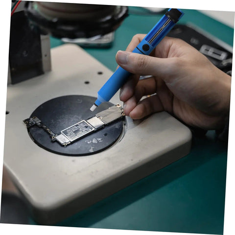 Person using two piece manual desoldering pump solder removal tool suction gun for PCB durable solder sucker on circuit board