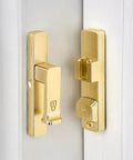 Heavy Duty Gold 90 Degree Barn Door Lock With Flip Gate Latch And Dual Secure Mounting Built Badass For Quick Install and shown on a white door.