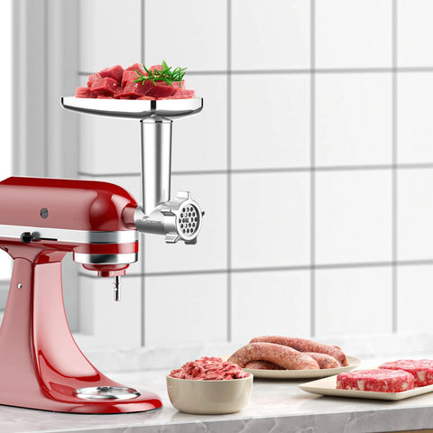 Metal meat grinder attachment for KitchenAid stand mixer; red mixer with chrome grinding head and meat chunks on tray