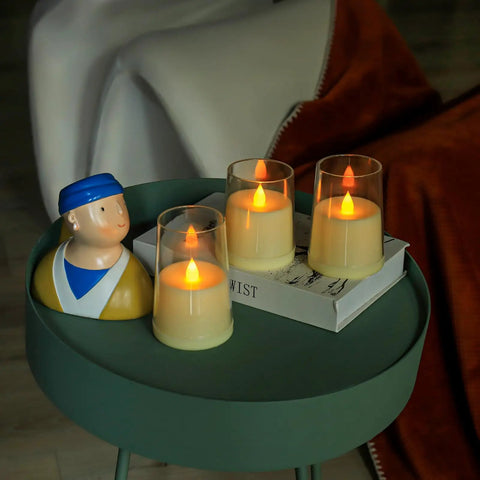 Ivory Flameless Taper Candles With Remote And Timer, Battery Operated LED Candles in glass holders on a green table