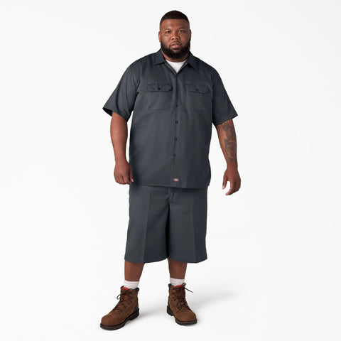 Badass Men Short Sleeve Utility Button Down Workshirt In Charcoal With Stain Resistant Cotton Polyester Blend For Tough Job Site Grind And Easy Relaxed Fit That Handles Every Day Hustle, model wearing charcoal shirt and shorts.