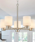 Modern brushed nickel five-light chandelier with white shades hung in a living room.