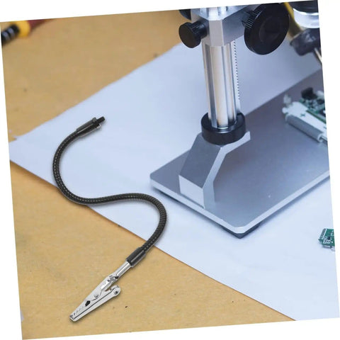 Close-up of adjustable soldering arm with magnifying glass and lamp clamp, showing flexible gooseneck holder on workstation