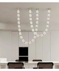 Sick Diamond Drop Pendant Light Featuring Hella Sleek Dimmable Led Design With Polished Gold Hardware And Sparkling Glass Shades, hanging above white dining table.