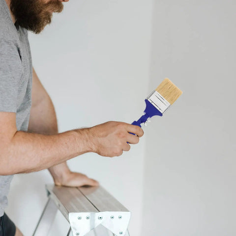 Man holding Pro Grade Adjustable 2.5 Inch Paddle Paint Brush with 270 Degree Angled Flat Tip for Oil and Latex Paint