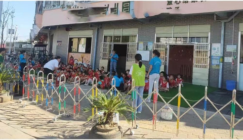 Built Different Retractable Barricade And Expandable Stainless Steel Safety Gate Roll Right Out For Garage Parking Lots And Crowd Control With Zero Hassle Flex And Smart Traffic Routing in use outside a school, separating children from the entrance.