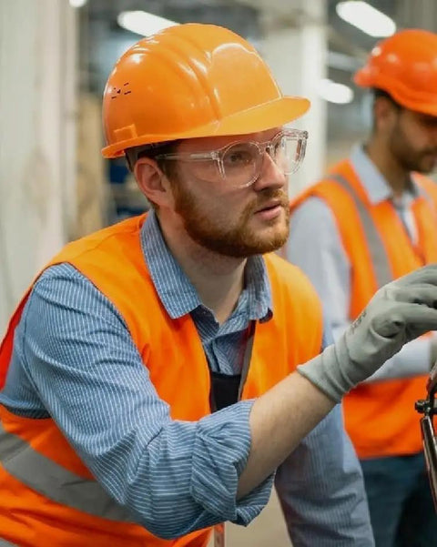 Heavy Duty Z87 Plus Safety Reading Specs With UV400 Side Shields And Impact Resistant Lenses worn by a worker in safety gear at a job site.