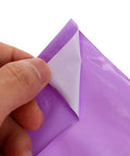 Close-up of violet poly mailer with waterproof seal being peeled open, part of 100 Pack Polyethylene Mail Bags With Waterproof Seal For Dope Durable Poly Mailers Great For Local And Long Distance Shipping Budget Friendly Packaging Supply For Clothing Cosmetics And Small Businesses.