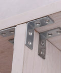 10 Pack Right Angle Corner Brackets For Furniture And Cabinets installed on wooden shelf, silver iron joint fasteners for heavy duty support.