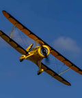 UMX Waco Yellow RC Airplane Bind-N-Fly BNF With AS3X And Safe Technology mid-flight against blue sky.
