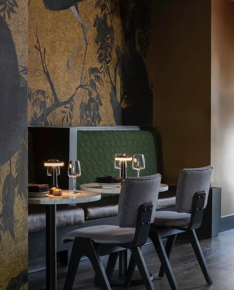 Dining table with Cordless Desk Lamp With USB Charging, Portable LED Table Light, compact and rechargeable, in a stylish restaurant.