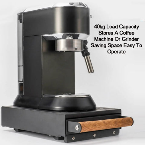 Sturdy Espresso Knocker Drawer And Coffee Knock Box With Shock Absorbing Removable Knock Bar Made From Durable Rubber And Steel To Corral Coffee Grounds Without Mess While Freeing Up Sweet Countertop Real Estate For Hassle Free Daily Shot Pulling Vibes next to a coffee machine.