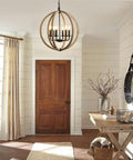 Orb 6 Light Farmhouse Chandelier In Brown Wood Finish With Globe Design Hanging in a Cozy Foyer