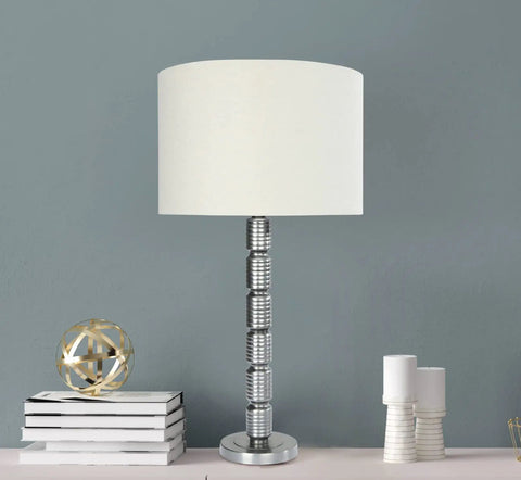 Faceted Metal Floor Lamp With Stacked Column Base, Aged Pewter Finish And Cream Linen Drum Shade in living room setting, Hadley Collection