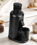 Sweet Spot 80 Mm Flat Burr Coffee Grinder With Variable Speed Control And Broad 0 To 100 Grind Scale Turning Out Butter Smooth Powder For Espresso Pour Over Drip And French Press Favorites In Matte Black on a kitchen counter with coffee beans.
