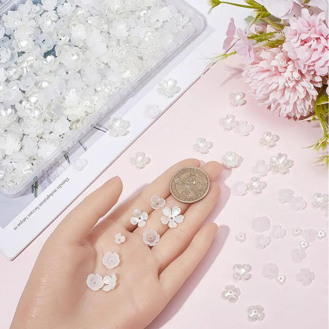 600Pcs Flower Bead Caps Set White And Clear 3 Petal 4 Petal 5 Petal Tulip Petal End Caps shown in hand with coin for scale