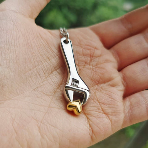 Hand holding Mechanic Wrench Cremation Urn Necklace For Ashes Holder Pendant Spanner Memorial Keepsake For Dad.