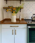 Six Pack Stripes Cabinet Pulls Antique Brass For Kitchen Cabinets And Dressers, shown on white cabinet, wood countertop.