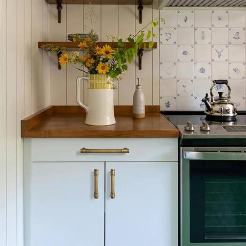Six Pack Stripes Cabinet Pulls Antique Brass For Kitchen Cabinets And Dressers, shown on white cabinet, wood countertop.