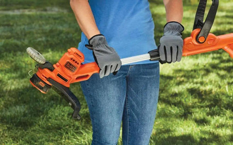 Person holding a corded electric weed wacker with 6.5 amp motor and 14 inch cutting deck, showing the 2 in 1 trimmer and edger.