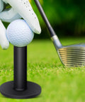 Close-up of a golf ball on black rubber tee from Rubber Golf Tees Set With Holders, Five Height Sizes for practice, on grass with club.