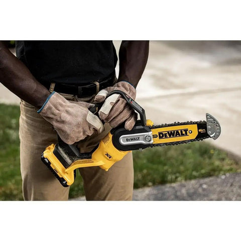 Person using Cordless Pruning Chainsaw 20V 8 Inch for quick yard trims, lightweight one hand comfort grip, DCCS623B, black and yellow tool.