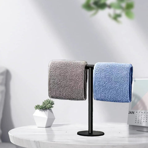 Hand Towel Holder Stand For Bathroom Vanity Countertop Matte Black Finish Free Standing Design Space Saving Movable T Shape Towel Bar Rack For Kitchen And Bath with folded towels on a table.