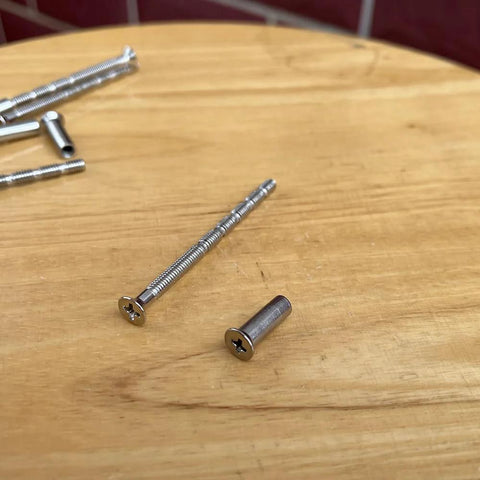 8 Set M4 X 60mm Breakaway Phillips Flat Countersunk Screws With Posts on wooden surface