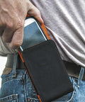 Person using Phone Holder With Magnetic Closure And Belt Clip For iPhone Google LG And Samsung on hip, made from durable 1680D nylon.