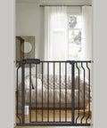 Extra Wide Baby Gate With Walk Through Door And Auto Close, EZ Install, Adjustable Pressure Mount Black Metal Safe Gate indoors.