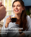Woman smiling holding a glass of coffee with 1200 Series Fully Automatic Espresso Machine With Classic Milk Frother Ceramic Grinder in background