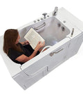 Sleek 32X52 Acrylic Transfer Walk In Tub With Heavy Duty Hydro Massage And Microbubble Jets Crafted For A No Sweat Fast Fill Setup And Right Side Dual Drain For Pure Chill Vibes, featuring user relaxing and reading.