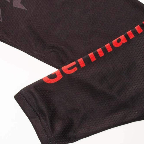 Close-up of black fabric sleeves with red lettering, showcasing texture and design.