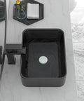 Black rectangular above-counter vessel sink on marble counter in modern bathroom.