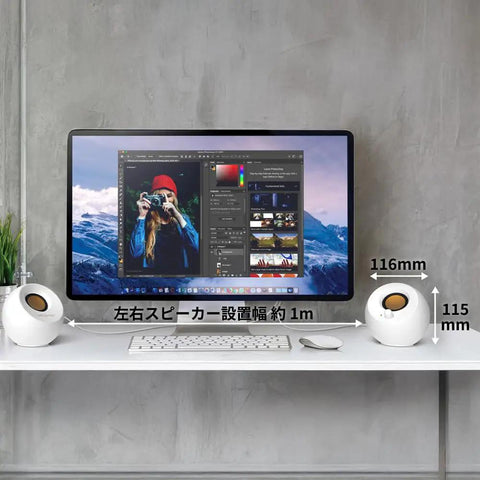 USB Powered Desk Speaker System With 4.4W Output, 45 Degree Upward Driver on white desk next to computer monitor.